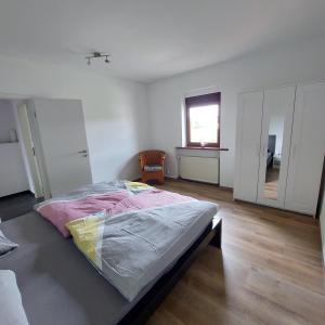 a white room with a bed and a chair in it at Wolfi in Sankt Wendel