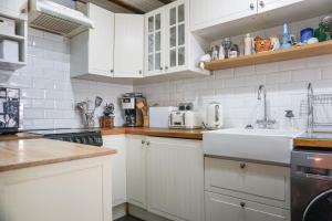 una cocina con armarios blancos y fregadero en The Croft, en Bridgnorth
