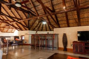 a large room with wooden ceilings and a television in it at Zebula Lodge 118 in Mabula