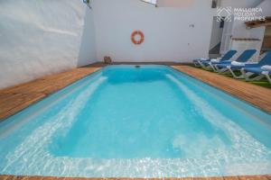 a large swimming pool with blue water in a room at Villa Fonte in Port de Pollensa