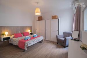 a small bedroom with a bed and a chair at Villa Fonte in Port de Pollensa