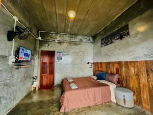 a bedroom with a bed in a concrete room at The Mae Homstayผาฮี้ in Ban Ko Doi Tung