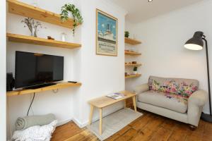 un soggiorno con divano e TV di Percy Terrace - Charming 2 bedroom town house a Portsmouth