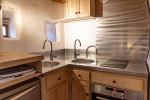 a kitchen with two sinks and a stove at Le Pigeonnier in Beynac-et-Cazenac