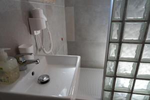 La salle de bains est pourvue d'un lavabo et d'une douche. dans l'établissement Hotel VM, à Rome