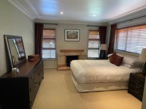 Un dormitorio con una cama grande y una chimenea. en Secluded Bays Home, en Auckland