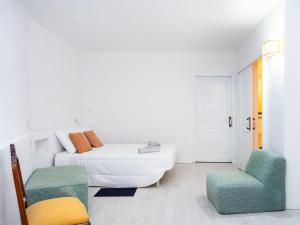 um quarto branco com uma cama e uma cadeira em Live Playa San Marcos Sayris Sea em Icod de los Vinos