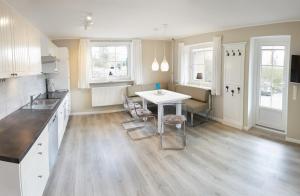 a kitchen with a table and chairs in a room at Ferienwohnung Seegras - mit Spielscheune, direkt am Wittensee in Bünsdorf +14 photos
