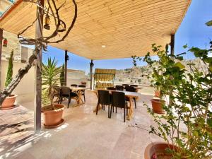 een patio met een tafel en stoelen en een aantal planten bij Villa Mira Guesthouse - Downtown Central Amman - AL DIYRIH in Amman