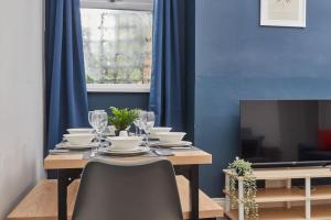 uma sala de jantar com uma mesa com cadeiras e uma televisão em Spacious 3-Bedroom House With Garden and Parking em Stockton-on-Tees
