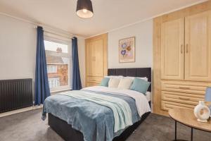 1 dormitorio con cama, mesa y ventana en Spacious 3-Bedroom House With Garden and Parking, en Stockton-on-Tees