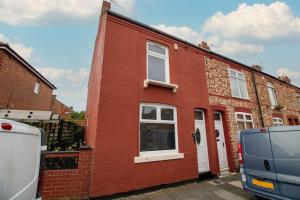 a red house with a van parked in front of it at Spacious 3-Bedroom House With Garden and Parking in Stockton-on-Tees