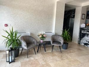 two chairs and a table with flowers on it at Hotel Del Ponte in Târgovişte