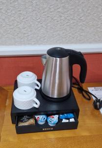 a coffee pot sitting on a tray on a table at Hotel des Arts - Cite Bergere in Paris