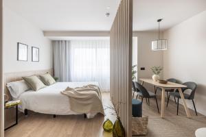1 dormitorio con 1 cama y 1 mesa con sillas en Líbere Madrid Chamberí en Madrid