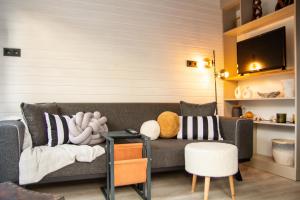 a living room with a couch and a tv at Tiny House Framed by Nature near Sea in Karaburun in İzmir