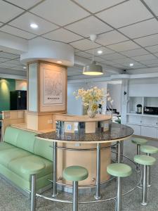 a lobby with a counter with green stools at Marni BKK Hostel in Bangkok