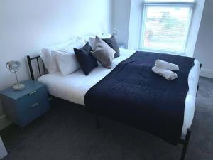 a bedroom with a large bed with two towels on it at 4-bedroom home with off-road parking in Swansea