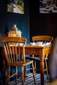 a wooden table with two chairs and a lantern on it at The Plough Inn Cabins in Ramsden