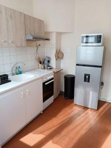 uma cozinha com um frigorífico branco e um lavatório em Maison avec jardin em Issoudun