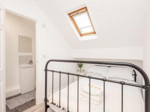 um quarto com uma cama de metal com almofadas brancas em Pass the Keys The Couples Nest close to Leeds city centre em Leeds