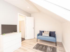 uma sala de estar com um sofá azul e uma televisão em Pass the Keys The Couples Nest close to Leeds city centre em Leeds
