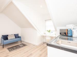 a kitchen with a sink and a blue couch at Pass the Keys The Couples Nest close to Leeds city centre in Leeds