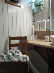 La salle de bains est pourvue d'un bureau, d'une chaise et de serviettes. dans l'établissement Hársfa apartman, à Makó