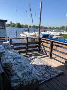 a bed on a dock with boats in the water at Villa Waterwolf in Aalsmeer