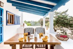 a wooden table on a patio with a blue ceiling at Can Toni Blay in Es Caló