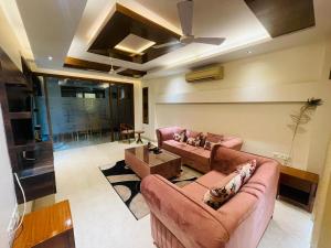 a living room with two couches and a ceiling fan at Divine India Service Apartment 4Bhk D-163 Saket in New Delhi