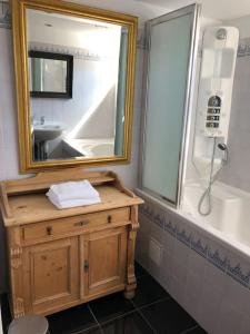 a bathroom with a sink and a mirror and a tub at Villa Waterwolf in Aalsmeer