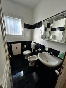 a black and white bathroom with two toilets and a sink at Casa Berizzi Mare - Arenzano Pineta in Arenzano