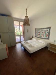a bedroom with a white bed and a large window at Casa Berizzi Mare - Arenzano Pineta in Arenzano