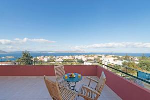 a patio with a table and chairs on a balcony at Villa Persephone by PosarelliVillas in Plaka