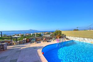 a swimming pool on a patio with a view of the ocean at Villa Persephone by PosarelliVillas in Plaka