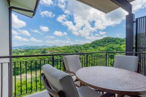 un balcone con tavolo e sedie e vista di Roble Sabana 404 Luxury Apartment Adults Only - Reserva Conchal a Playa Conchal