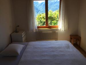 ein Schlafzimmer mit einem Bett und einem großen Fenster in der Unterkunft Catarina in Contra