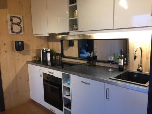 a kitchen with white cabinets and a black counter top at My Happy Box in Ochsenfurt