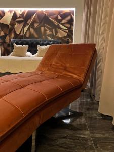 a brown leather bench in front of a bed at Loft Sirmione in Sirmione