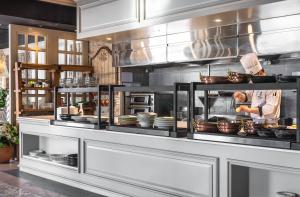 a chef preparing food in a large kitchen at Kensington Hotel Pyeongchang in Pyeongchang