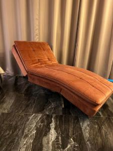 un banc en cuir brun assis devant un rideau dans l'établissement Loft Sirmione, à Sirmione