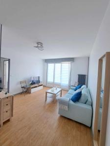 sala de estar con sofá azul y mesa en charmant-appartement-centre-ville Reims, en Reims