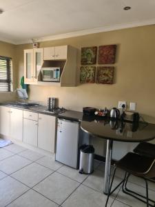 a kitchen with a table and a counter top at Perfek Stay Guesthouse in Secunda