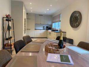 a dining room table with a bottle of wine on it at Maison de Quarreux in Aywaille