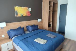 1 dormitorio con cama azul y almohadas azules en H&W Sunway Onsen Suite Tambun Sunway City Ipoh, en Ipoh