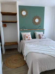 una camera da letto con un letto e due specchi sul muro di Chez Claudine APPART COSY a Château-Gontier