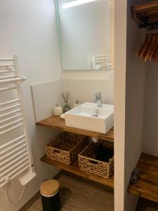 a bathroom with a sink and a mirror at Chez Claudine APPART COSY in Château-Gontier