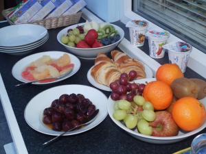 a table topped with plates of fruit and pastries at Padog B&B in Llanrwst