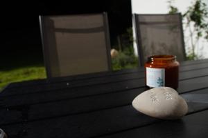 a jar of jam sitting on a table with a rock at Albsommer - Fehlatal Ferienhäuser in Burladingen